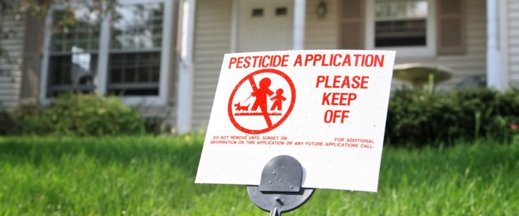 Pesticide application warning sign on lawn