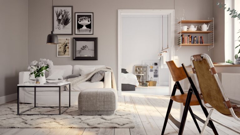 A cozy living room featuring a white table and a matching chair, with warm lighting and decorative elements.