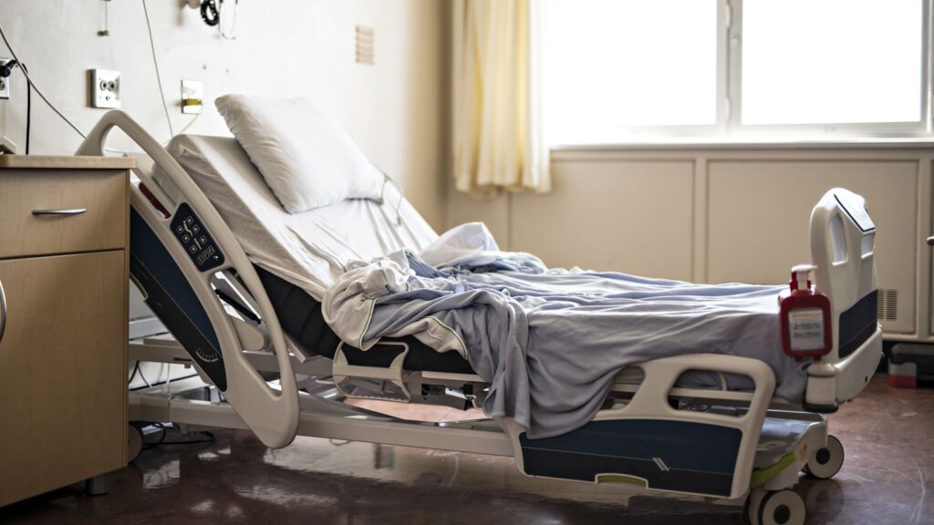Hospital bed with a neatly arranged blanket, ready for patient use.